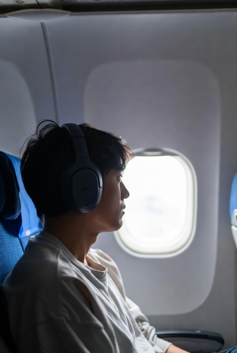 Generic Airplane Passenger Airplane passenger with headphones on looks out the window.