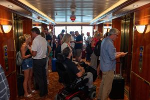 A crowded hallway in front of an elevator on a cruise ship