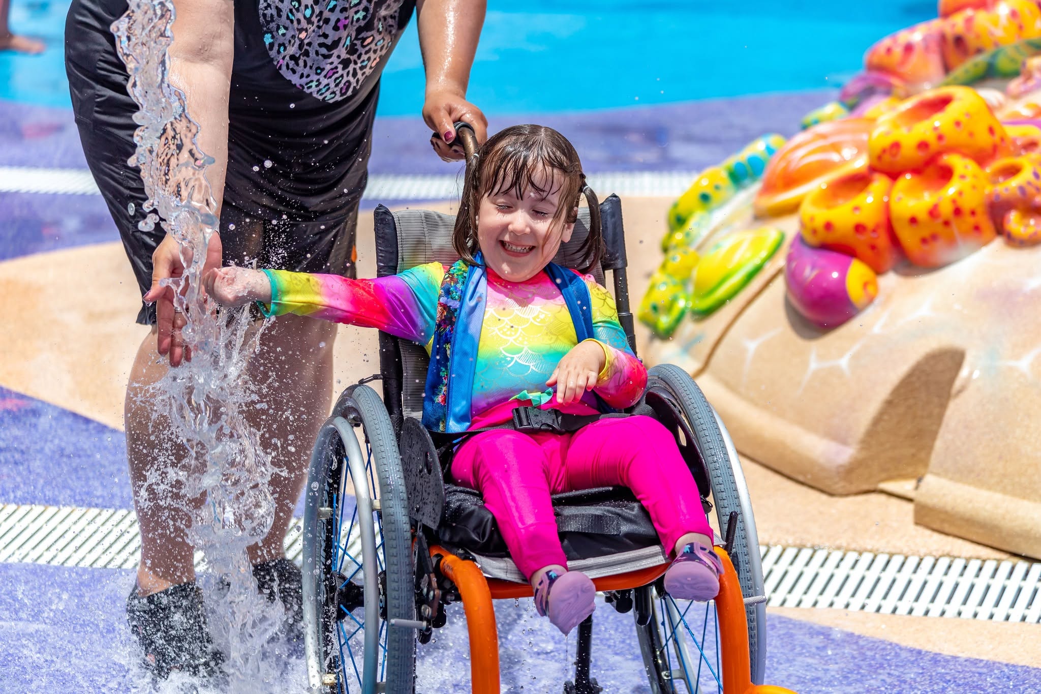 MorgansSplashPad A child in a wheelchair enjoying a splash pad at Morgans Inspiration Island.